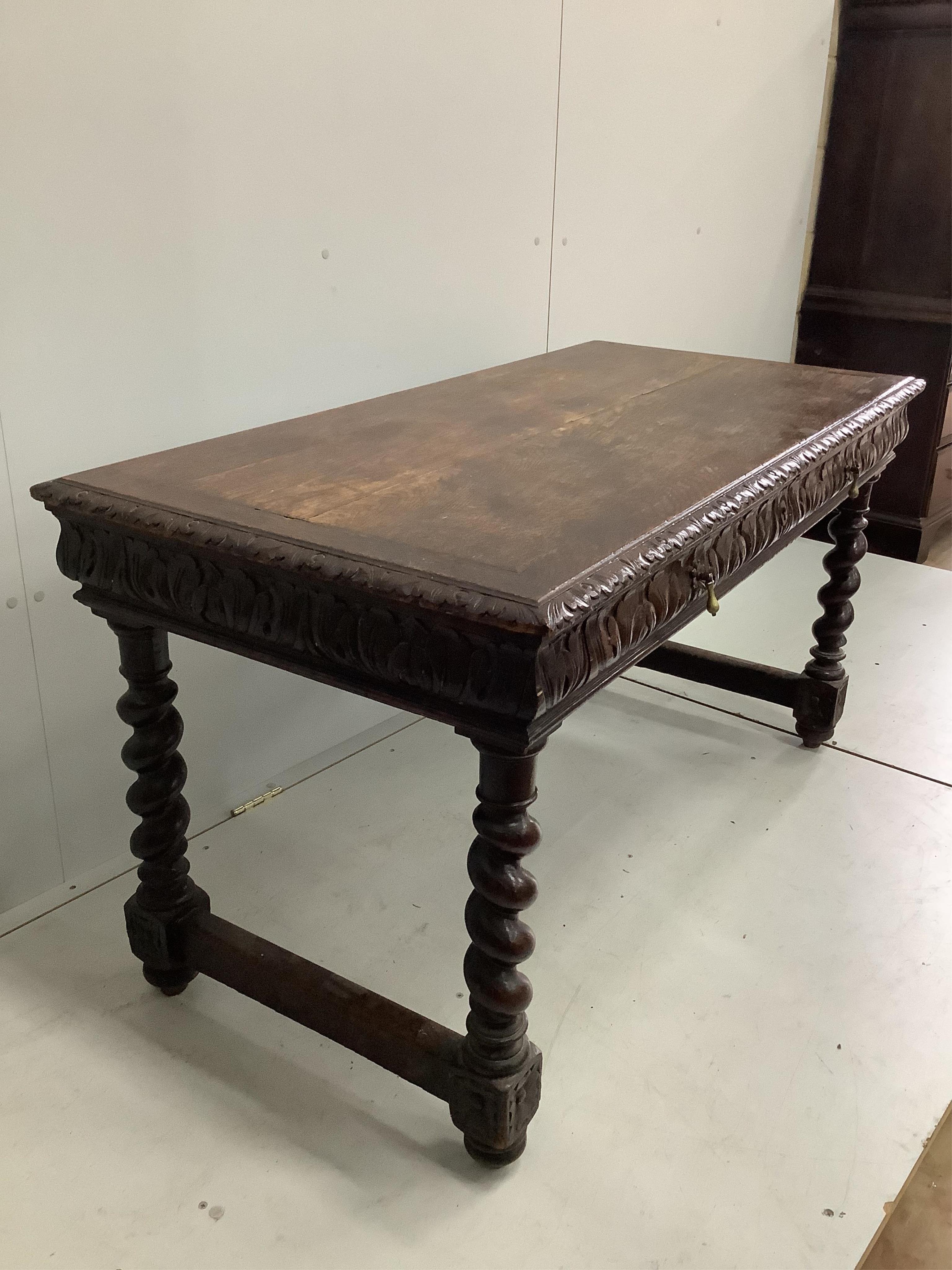 An early 20th century carved oak two drawer writing table, width 133cm, depth 67cm, height 72cm. Condition - fair